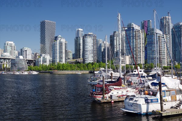 Small boats and yachts in front of skyscraper canyons