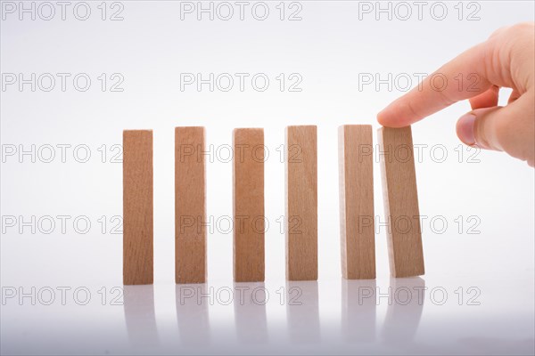 Hand holding wooden domino on a white background