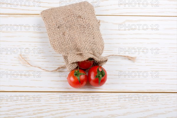 Little canvas sack and red ripe tasty fresh cherry tomatos