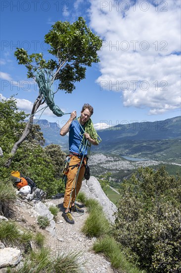 Climber throws climbing rope over his shoulder