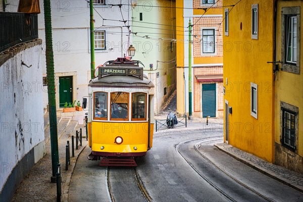 Famous vintage yellow tram 28 in the narrow streets of Alfama district in Lisbon