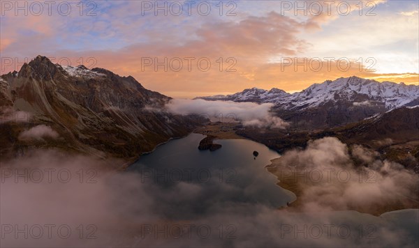Aerial view over the fog and Lake Sils shortly in front of sunrise in autumn