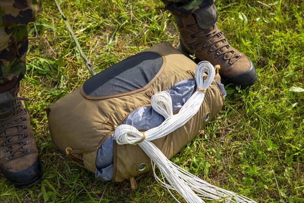 Military Parachuter Standing on the Grass with His Parachute in Switzerland