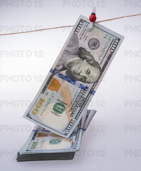 Banknote of US dollar hanging on a linen string