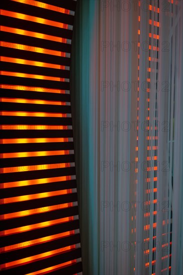 Illuminated Orange Stripes on a Modern Column in Switzerland