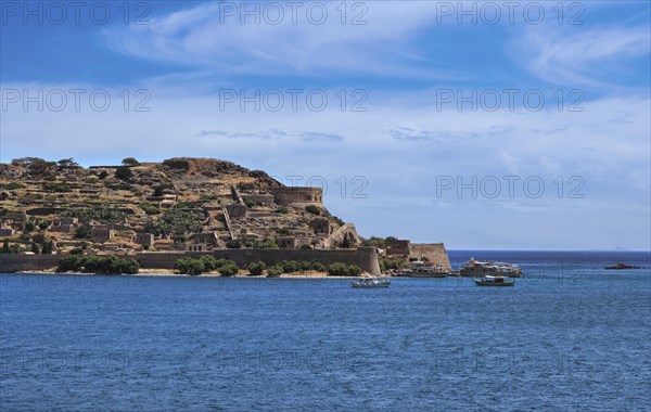 Beautiful view of west bank of Spinalonga island and Venetian fortress on clear sunny summer day on Crete