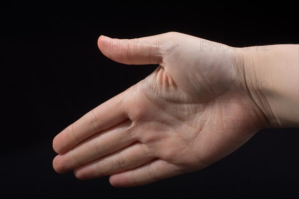 Five fingers of a child hand partly seen in black background