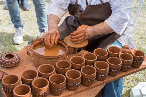 Potter`s hands shaping up the clay of the pot