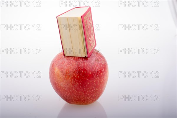 Red apple and Islamic Holy Book Quran in mini size