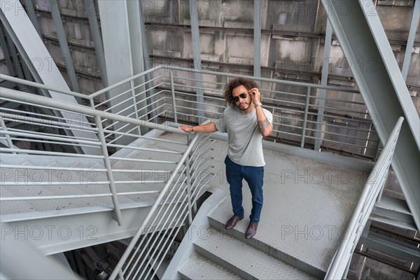 Young man with afro hair on the stairs in the city