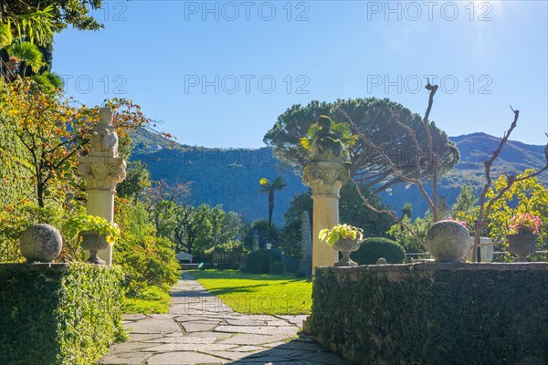 Patio with Statue on Column in the Forest on the Mountain Side and Blue Clear Sky in Park Scherrer in Morcote