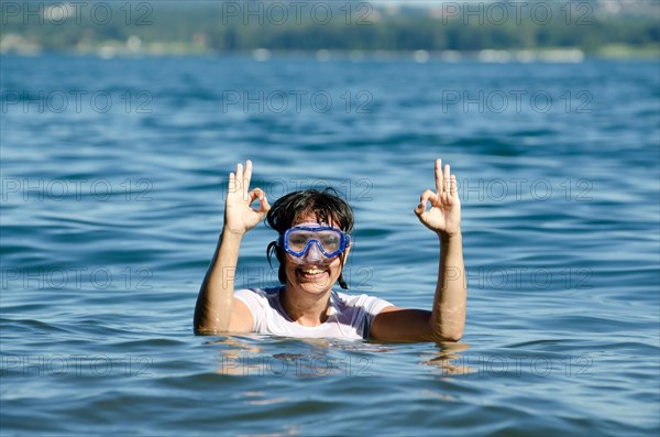 Woman with Diving Mask in the Water and Showing the OK Signal in Switzerland