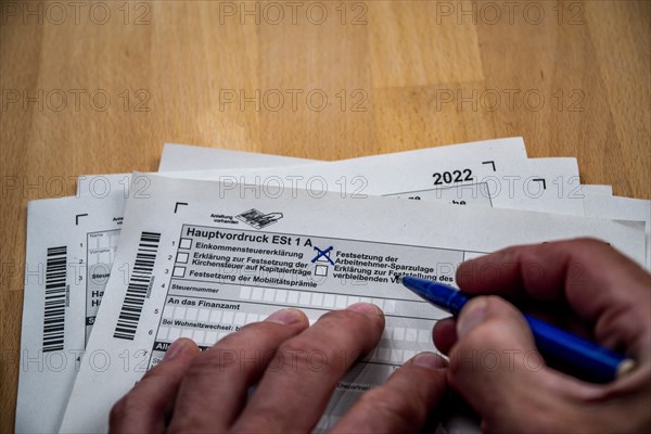 Male hand with biros in front of income tax declaration form