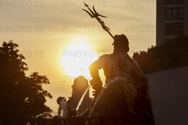 The sun sets behind the Neptune Fountain. Berlin