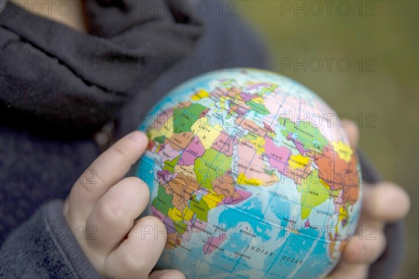 Save the Earth. Child holding a globe in the band