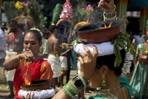 A Hindu woman carries a fire bowl during the big procession Theer