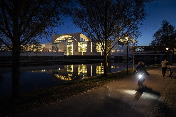 Cyclists in front of the Federal Chancellery at blue hour
