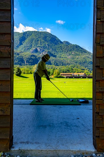 Golfer on Driving Range with Mountain in Switzerland