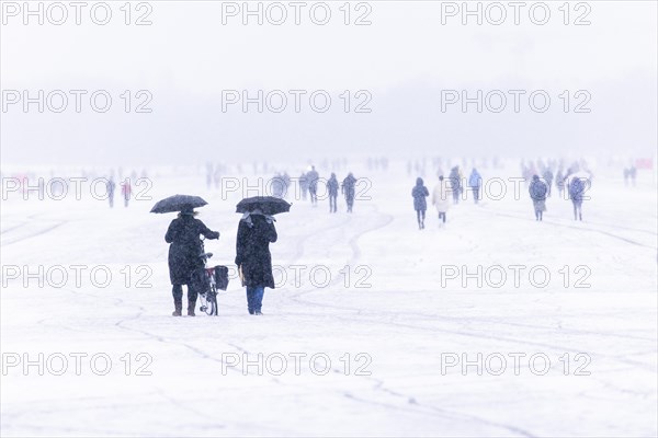 Berliners walk across Tempelhofer Feld in Berlin during snowfall