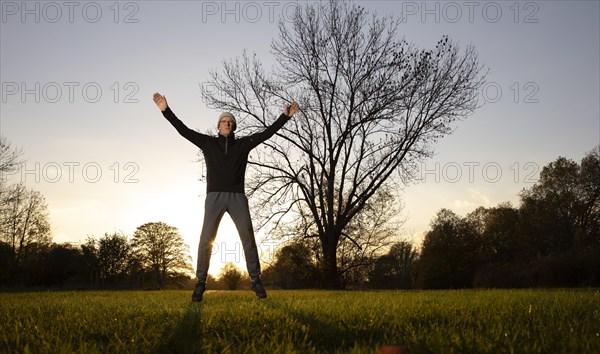 Man doing early morning exercise in autumn in a meadow.