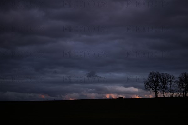 A car stands out on a country road at blue hour in Vierkirchen