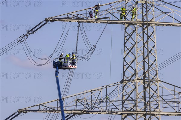 High-voltage pylon with fitters with cherry picker