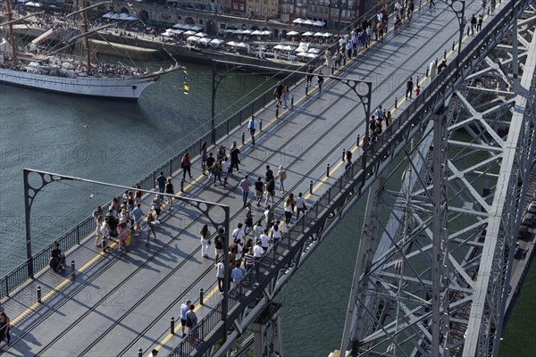 Pedestrians walking across the upper deck of the Ponte D. Luis I