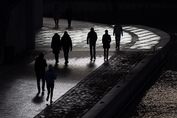 People stand out on the banks of the Spree in Berlin