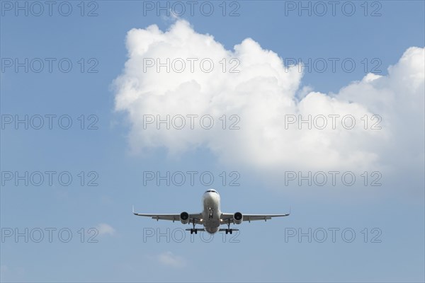 Passenger aircraft against a blue sky on approach to Hamburg Airport