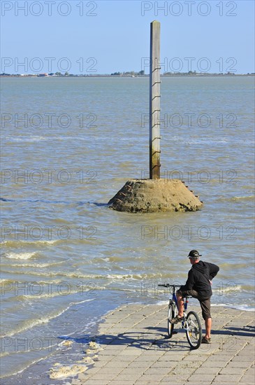 Tourist waiting for low tide to uncover the Passage du Gois