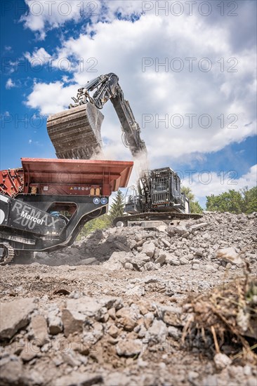 Demolition site with recycling plant and excavator