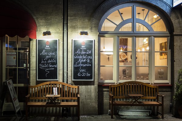 Two signs at a restaurant indicate meals 'to go' in Berlin