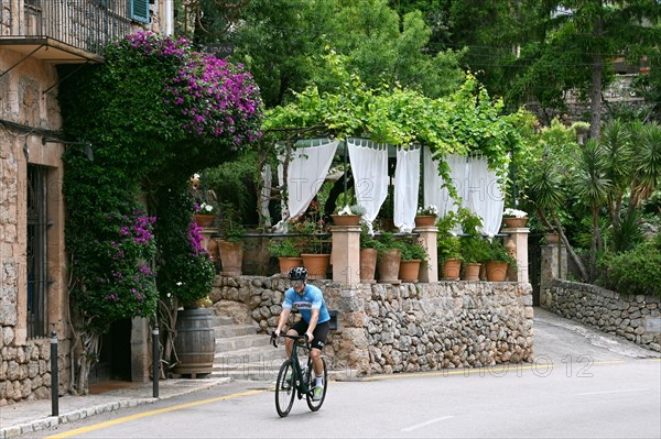 Racing cyclists in the artists' village of Deia on the edge of the Tramuntana mountains