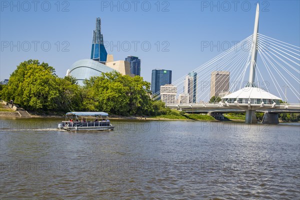 View from the Tache Promenade onto the Red River with Provencher Bridge and the skyline of Winnipeg behind