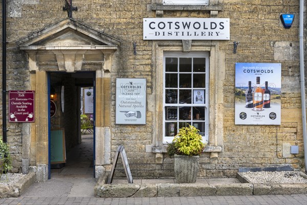Old stone house in detail with sales shop of the Cotswolds Distillery in the old town of Bourton on the Water
