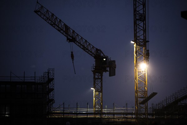 Cranes loom at a construction site in Berlin