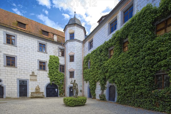 Inner courtyard of Mitwitz moated castle with Neptune fountain and sandstone statue of The Franconian Knight