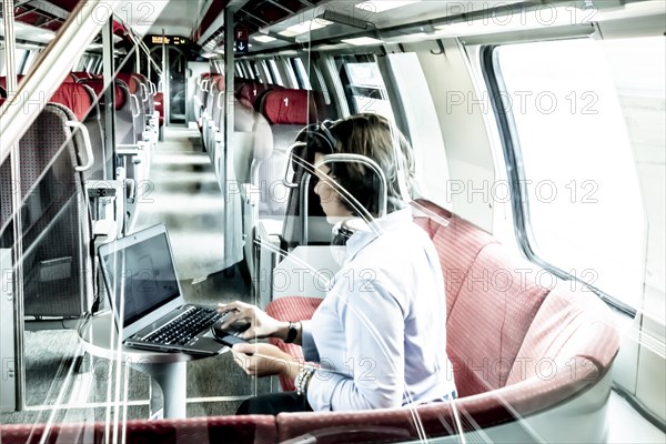 Woman Working on Laptop in First Class in a Train in Switzerland