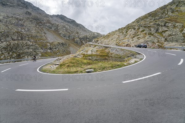 Cyclist and car on pass road