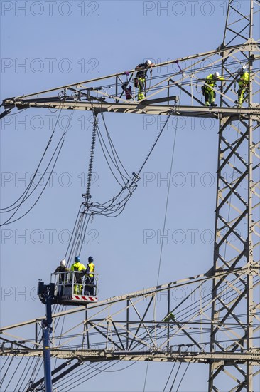 High-voltage pylon with fitters with cherry picker