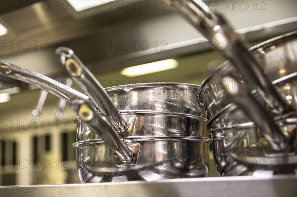 Unused stacked frying pans in a restaurant kitchen in Berlin