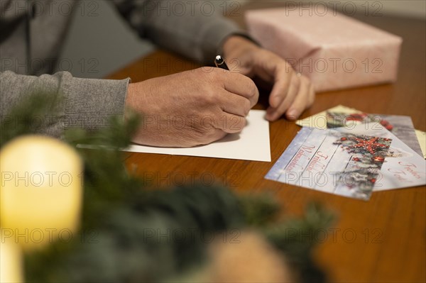 Merry Christmas. Man writing Christmas cards by hand. Handwriting