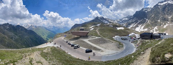 Panoramic view of pass road Alpine pass mountain road pass height of 2509 metres high Timmelsjoch Passo Rombo with pass museum rises from right Austrian territory to left in air of Italian territory