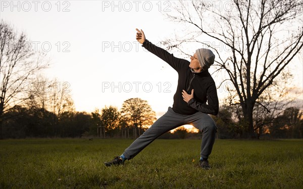 Man doing chi gong outdoors in the evening light