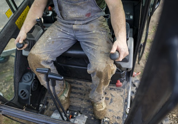 A construction worker controls the levers of an excavator. Berlin