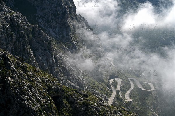 The winding road from Sa Calobra to Coll dels Reis in the Tramuntana Mountains with clouds