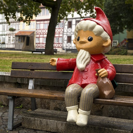 Sculpture of the Sandman on a bench in front of half-timbered houses on Kraemerbruecke in Erfurt