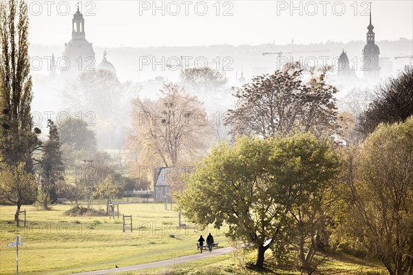 A couple walking along the Elbe meadows against the backdrop of Dresden's old town