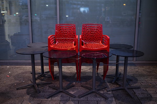 Assembled chairs and tables stand out in front of a closed cafe in Berlin