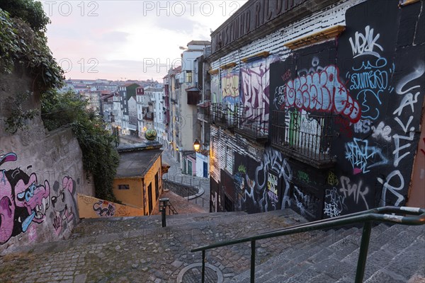 Steep staircase alley with wild graffiti at dusk